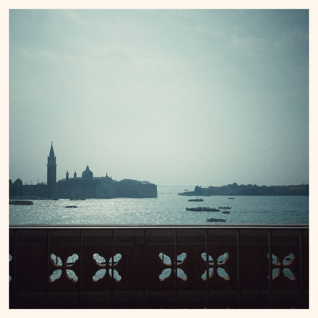 Venice seaside seen from the palace window, right into the sun. Extremely hazy. A strong wall with flower cutouts in front.