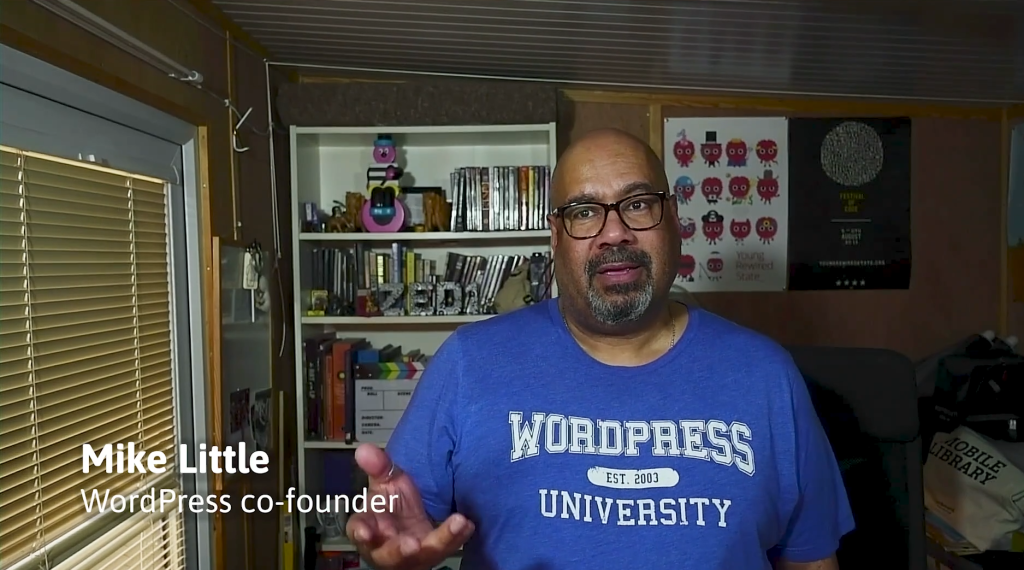Mike Little. A black man with shaved head, glasses, one hand out-stretched. Title card reads "Mike Little, co-founder WordPress"