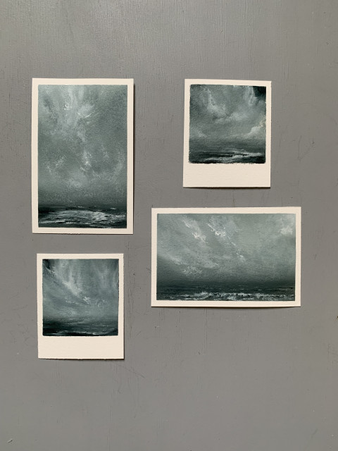 Photo of four original seascape oil paintings on paper by Tisha Mark. The seascapes are painted in a limited palette of dark blues, grays, and white to offer a stormy mood. 