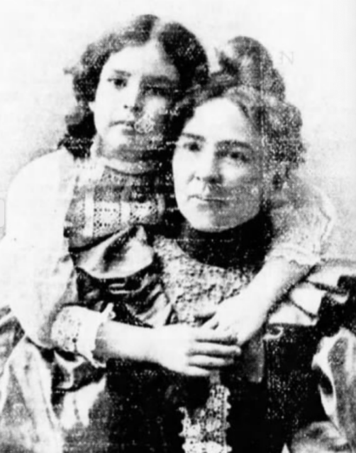 A white woman in ruffled dress, with a white girl behind her; the girl's arms are wrapped around the woman, and their faces are held close together

No photographer credited - WT (1901-03-30)."Rebecca Lee Dorsey, M.D." The Cecil Whig. p. 1.