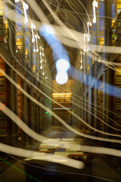 Foto der Alten Universitätsbibliothek in Kopenhagen. Die Kamera wurde während der Belichtung bewegt, so dass alle Lichter verwischt sind. Die Lampen in der oberen Etage sehen dadurch aus wie Musiknoten.
