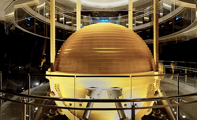 A giant golden ball, suspended from cables, with hydraulic pistons that slow side-to-side movement.