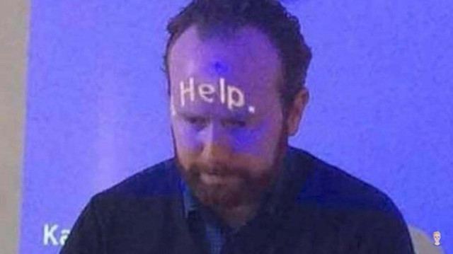 Man with “Help.” written on his forehead