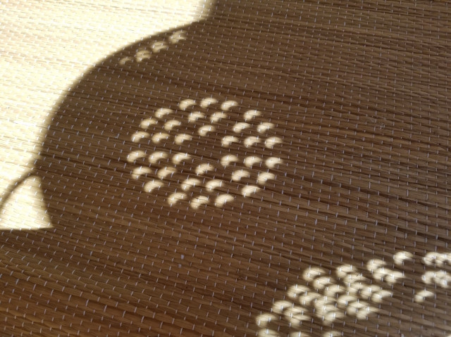A projection of light on a mat, each of the 36 holes in the colander shows a crescent where the moon was crossing the sun.  Normally you'd see circles of light as sunlight streams through each hole