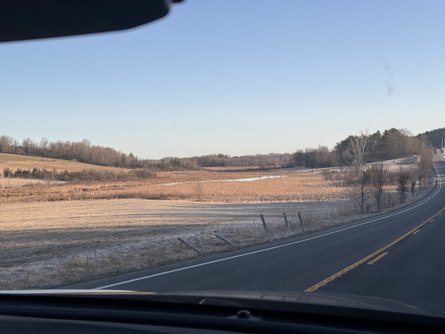 A photo from a few minutes before of some frost covered farm fields with nothing on them