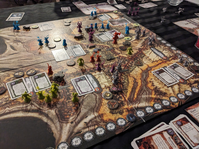 A shot of the Chaos in the Old World board with player minis and cards played on each of the regions