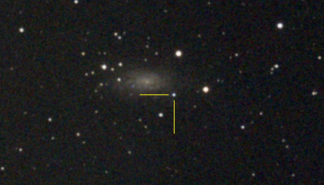 grainy image of a galaxy with one particular star is annotated with yellow cross-hairs.