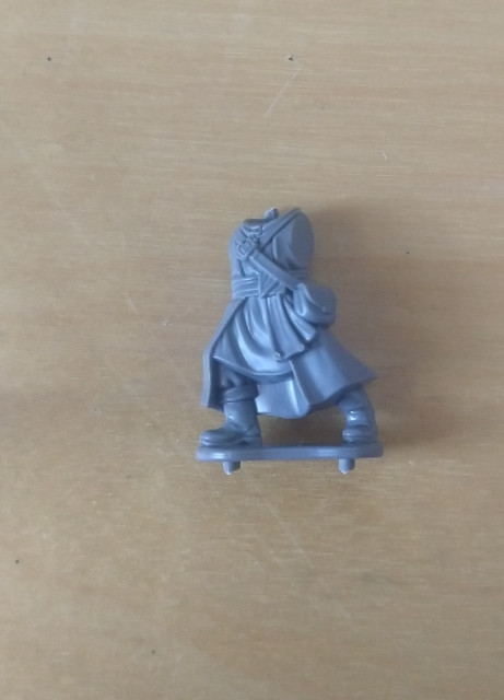 Closeup of the body from a Wizards set, without head or arms. It has an integral base, with bits of the sprue still sticking out.