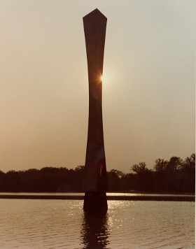 Wilson’s “Hyperbolic Obelisk” is a 32-foot tall tower with sides that curve slightly inward in the shape of a gentle hyperbola. In this photo the sun is just behind the obelisk, rendering it in silhouette.