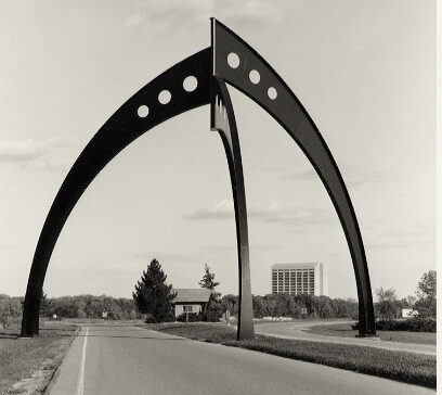 Wilson’s sculpture “Broken Symmetry” consists of three arched legs that come together in a slightly misaligned formation. From beneath it looks perfectly symmetric. From any other angle the components don’t quite align. The effect is reminiscent of the physics concept of a broken symmetry.
