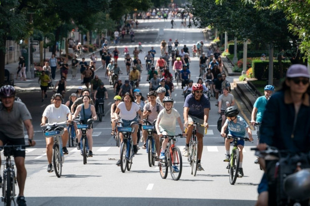 people using a street on bicycles.