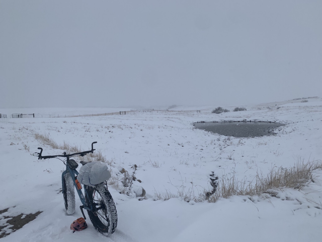 A blue fatbike in an April snowstorm on the East bench north of Red Lodge Montana 