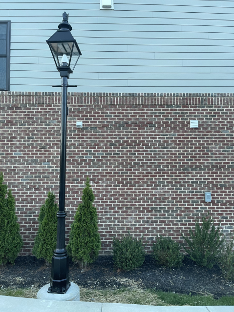 Picture of a street lamp. Probably 15 feet tall? Next to a sidewalk.