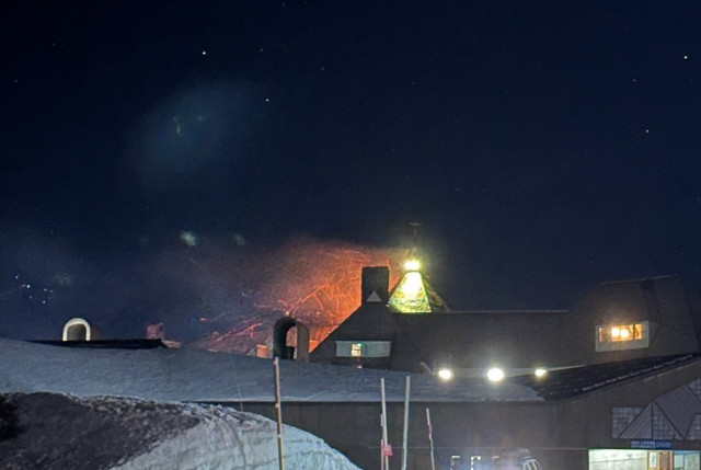 Fire on timberline lodge in the snow at night. Sparks fly sideways.