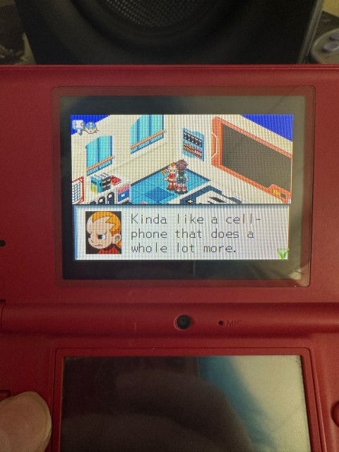 A DSi running MegaMan Battle Network
A character on the screen says “Kinda like a cell-phone that does a whole lot more.”