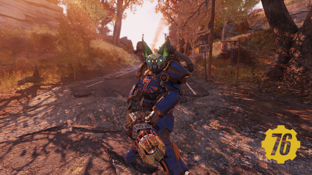 A player character in the game Fallout 76 wearing Power Armor that is painted blue and orange with a 'lucky 7" on the chest plate. The character is wearing the rare Glowing Scorchbeast Queen mask from the Fasnacht event. The character is on a road with autumn colored trees lining it and a smoke from a flare in the backdrop. The character is also holding a weapon known as a Gatling Plasma.