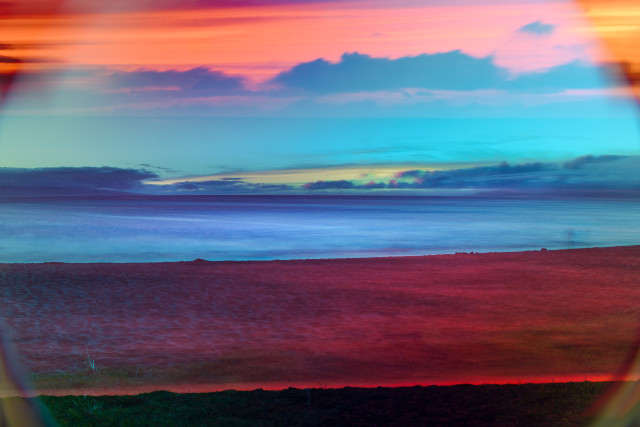 A beach landscape, double exposed and colored in blue and deep red.