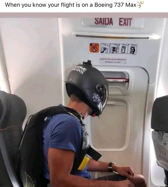 Man in exit row of airplane with helmet and parachute.