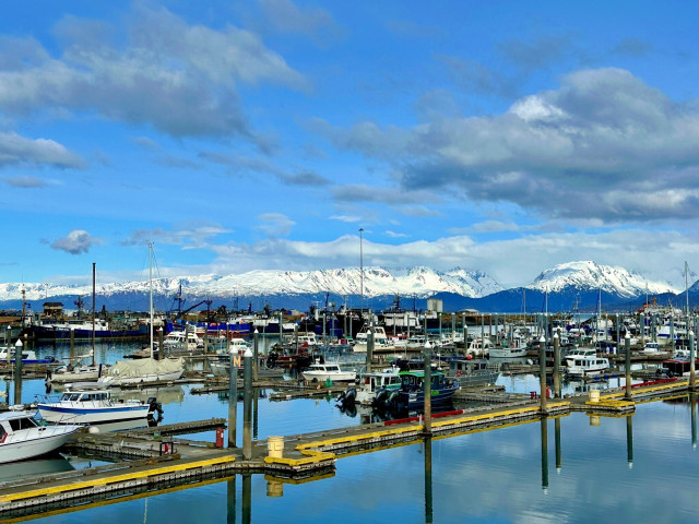 A beautiful shot of the boat harbor, boats and lovely snow-covered mountains in the background