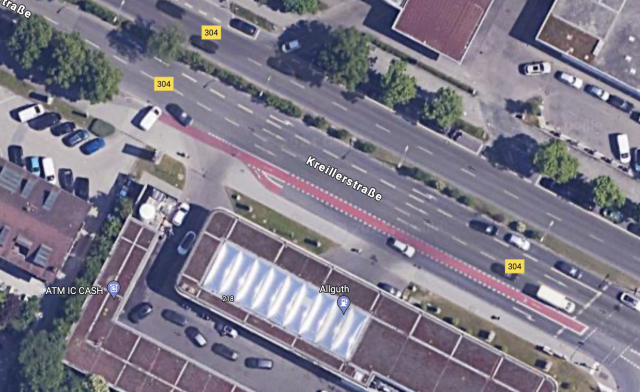 Satellitenbild Kreillerstrasse Ecke Bajuwarenstrasse in München. Von links kommt ein Radweg, der mitten auf den Kreuzungsbereich führt. Hier mischt sich der Radverkehr mit den rechts abbiegenden Autos, was eine Gefahrensituation heraufbeschwört.