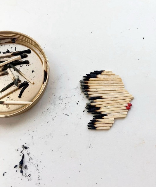 Photography. A color photo of burnt matches arranged into a small work of art. A shallow golden bowl with burnt matches stands on a white table. Next to it are burnt and new matches with red heads, shortened and placed in such a way that they form a female face with red lips and short black hair. Simply a beautiful idea.