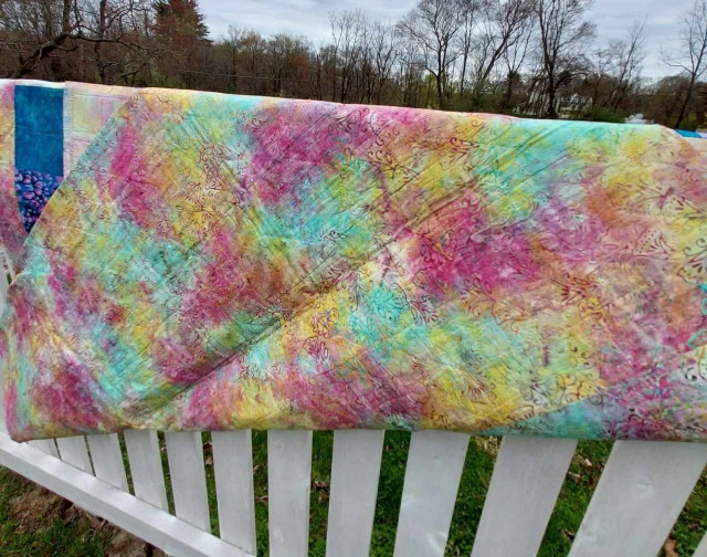 the back of the quilt, soft pastel tones of yellow, aqua green / blue , and pink together 