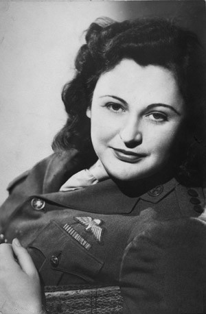 Studio portrait of Nancy Wake in uniform, showing her parachute badge. She is a white woman with dark hair.