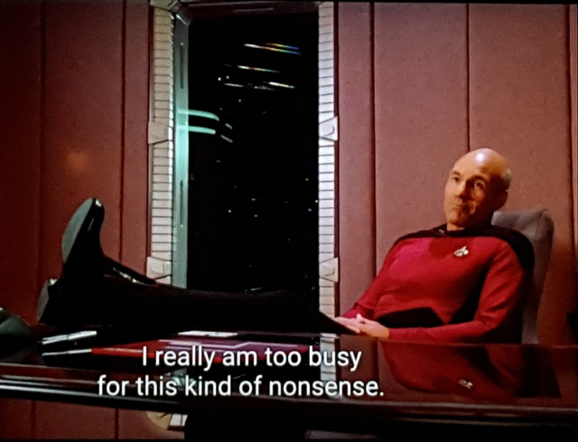 TNG scene. Picard is in his ready room, feet up on the desk all relaxed like. BUT, he does still have his serious Picard face on. Closed caption reads, "I really am too busy for this kind of nonsense."