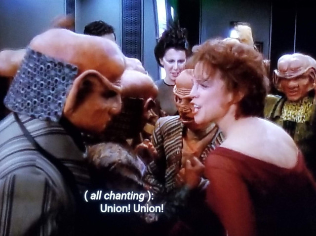 DS9 scene. A humanoid Bajoran (Leeta) with a bit of nose loaf is standing in the middle of a group of Ferengi. She looks super pumped up and is cheering them on. Closed caption reads, "(all chanting): Union! Union!"

Happy International Worker's Day everyone