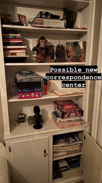Text: Possible new correspondence center 
On top of a photo of a built in bookcase that currently contains books and games and knickknacks.  