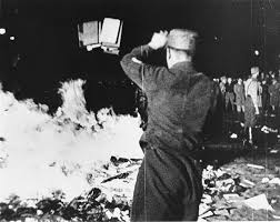 Picture of a man in uniform throwing books onto a fire.