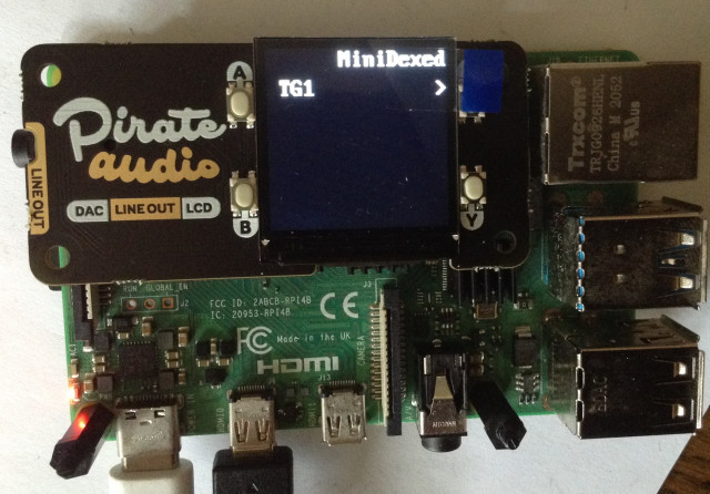 Photo of a Pimoroni Pirate Audio hat on a Raspberry Pi 4 with the display showing "MiniDexed" and "TG1".