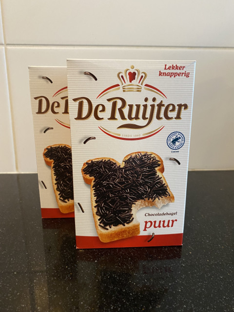 Photo of two packs of De Ruijter Chocoladehagelslag on a black kitchen counter.