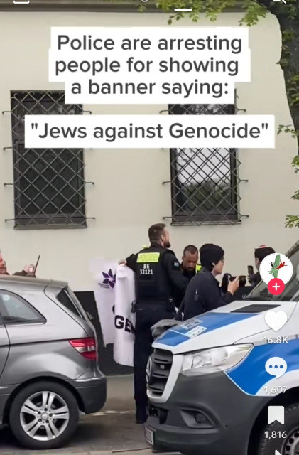 screen capture of German police arresting a man holding a banner Jews Against Genocide