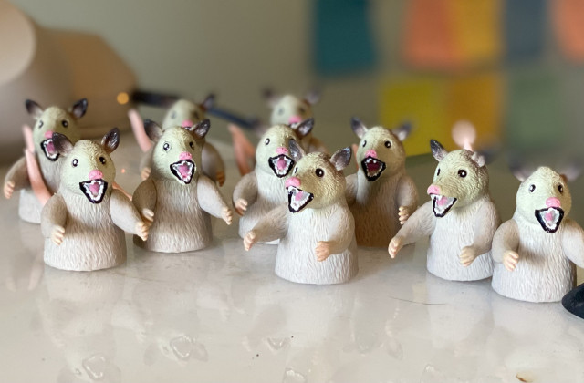 An assortment of possum finger puppets sits on a desk top