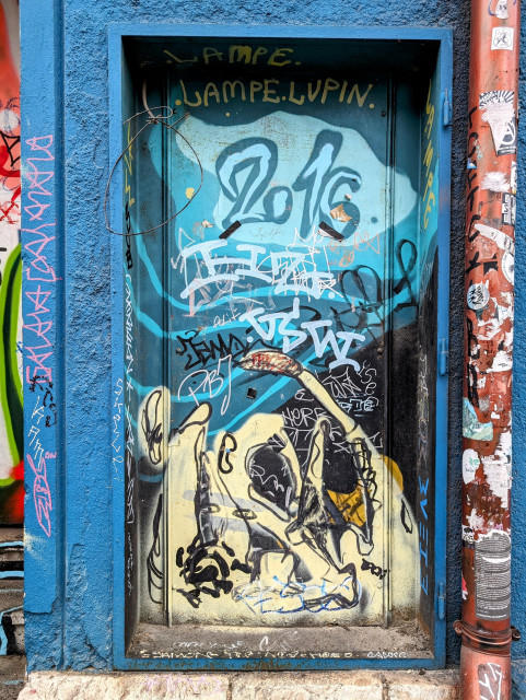 Eine mit Graffiti überzogene Türe. Prominent ist die Zahl 2016 zu lesen.