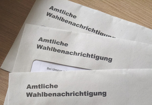 Paper election notices in the form of a letter lying on a table.