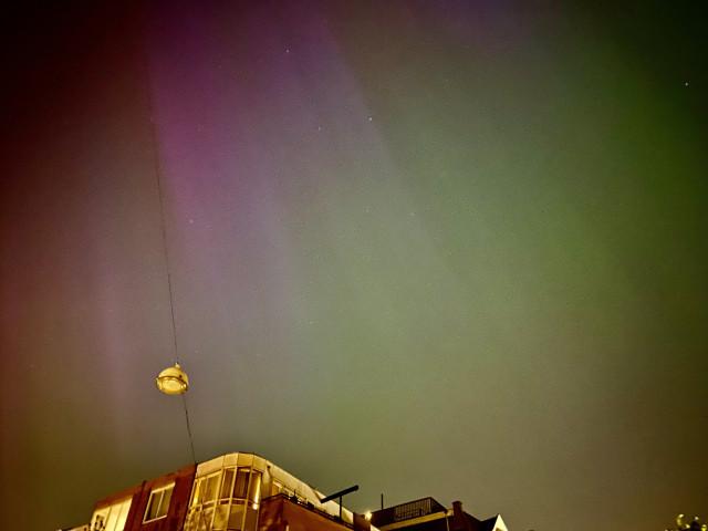 Photo taken at night, in #Amsterdam #IndischeBuurt on an #iPhone
It shows mostly sky and the upper part of some residential buildings. The sky has a slight structure of vertical, colored bands.