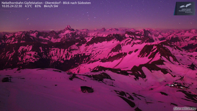 Nighttime view from the Nebelhorn summit over the still largely snow covered High Allgäu Alps (the ridge just north of Oytal) towards the Hochvogel pyramid. The entire scene tinted pink by the light of the aurora.