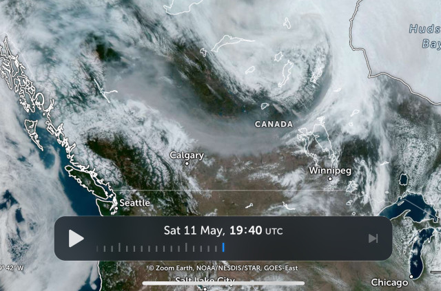 A satellite image of Western Canada showing smoke drifting from near Fort Nelsen, B.C. to Edmonton and then the north end of Lake Winnipeg.
