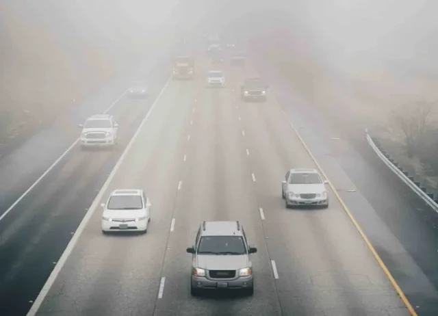 Cars driving through smog.