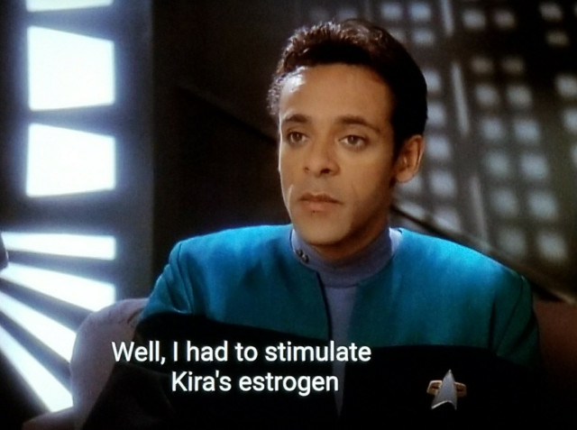 DS9 scene. Bashir is pictured on station sitting and thinking with a look of vacant existential dread.  Closed caption reads, "Well, I had to stimulate Kira's estrogen"