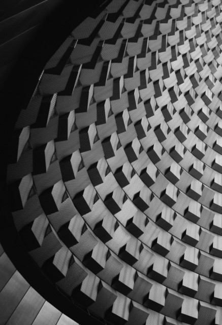 Black and white photo of an abstract, geometric pattern with interlocking, three-dimensional shapes.