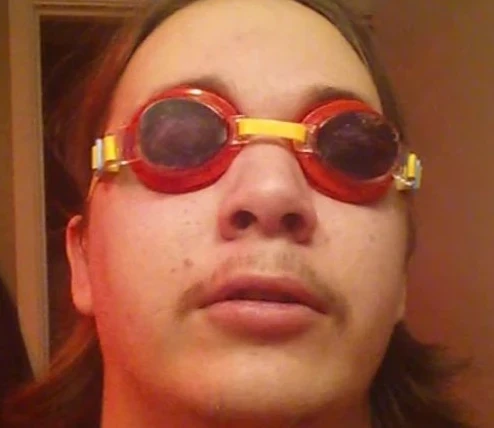 guy wearing swimming goggles a size too small for his face with a pencil mustache