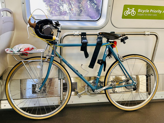 A photo of a blue Rivendell road standard from the 90s, in a SF BART train