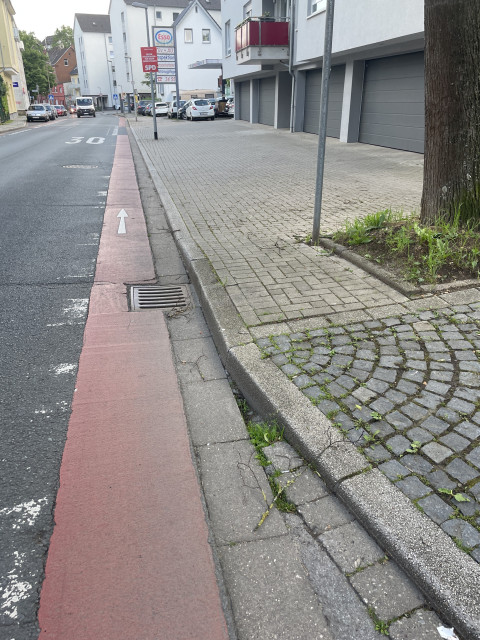 a cycle lane at the edge of a road in Herdecke - the drains have sunk below road level