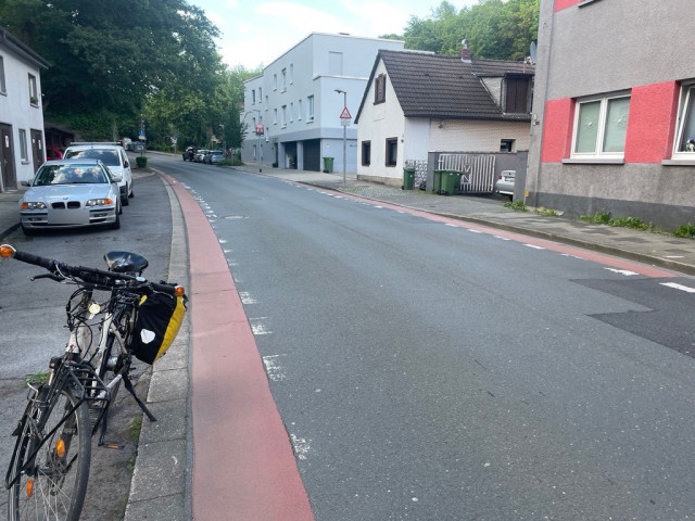 A road in Herdecke with very narrow cycle lanes marked in red at the side of the road for each direction of travel.