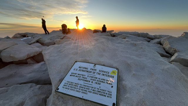The old original official summit plaque bolted to a rock on the summit of Mount Whitney during sunrise