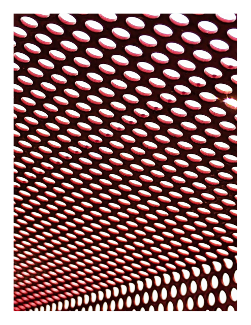 angled view of dark red steel mesh with round openings against a white background