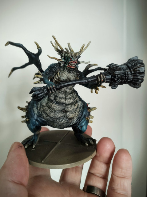 A plastic model of the Asylum Demon from Dark Souls. It is basically just a big butt with horns and a huge club. Right now it's painted a dark turquoise and something resembling bone.